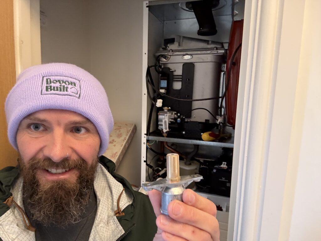 Emergency plumber fixing a leaking boiler pipe in a home in Exmouth